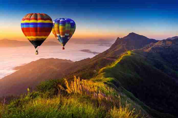 Landscape of morning fog and mountains with hot air balloons at